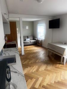 ein Wohnzimmer mit einem Sofa und Holzböden in der Unterkunft The Flat in Royal Wootton Bassett