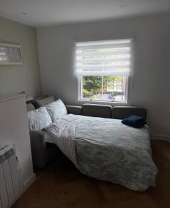 ein Schlafzimmer mit einem Bett und einer Couch und einem Fenster in der Unterkunft The Flat in Royal Wootton Bassett