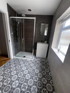 ein Bad mit Dusche und Fliesenboden in der Unterkunft The Flat in Royal Wootton Bassett
