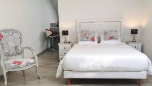ein Schlafzimmer mit einem weißen Bett und einem Stuhl in der Unterkunft Studios MISTRAL21 en Camargue in Salin-de-Giraud