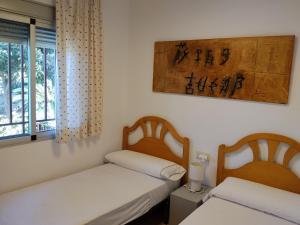 una habitación con dos camas y una ventana en La Casa Maria, en Pego