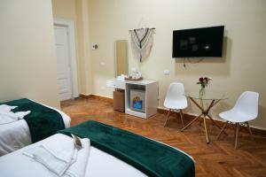 a hotel room with two beds and a table and a tv at Hathor House in Cairo