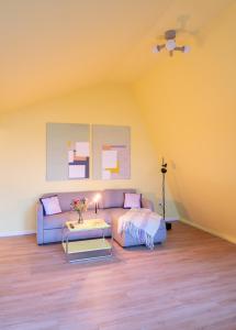 a living room with a couch and a table at Design-Apartment Worpswede in Worpswede