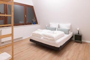 a bedroom with a bed with white sheets and a window at Design-Apartment Worpswede in Worpswede