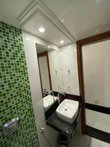 a bathroom with a sink and a mirror at Próximo a praia das castanheiras, internet, cooler, cadeiras de praia,roupas de cama e banho in Guarapari +18 photos
