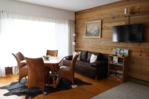 a dining room with a table and a couch at Wohlfühlstudio Bergblick in Walchsee in Walchsee