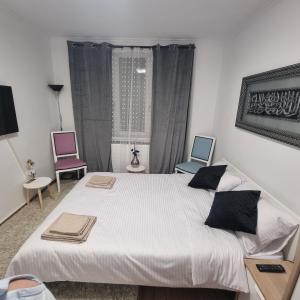 Un dormitorio con una cama grande y dos sillas. en Apartament Flavia, en Craiova