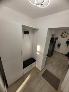 a room with a white wall with a bench and a clock at Casa Lumy in Petrila