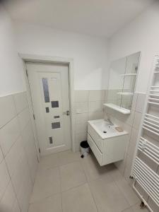 a white bathroom with a sink and a mirror at Casa Lumy in Petrila +14 photos