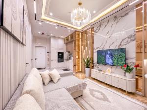 a living room with a couch and a tv at Nest One Luxe, Элитные апартаменты с террасой и панорамным видом 067 in Tashkent