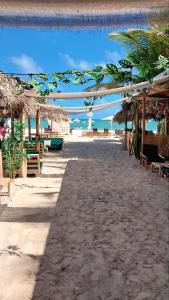 einen Strand mit Tischen und Stühlen und das Meer in der Unterkunft Beach Lounge Punta Cana Aparthotel 1 in Punta Cana