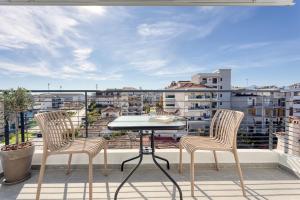 un patio avec deux chaises et une table sur un balcon dans l'établissement V P Trikala Luxury Suites, à Tríkala