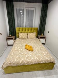 a bedroom with a bed with a yellow headboard at Welcome to Dovas Home in Anykščiai