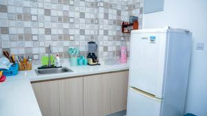 a kitchen with a white refrigerator and a sink at Zanzibar Cozy Home in Zanzibar City