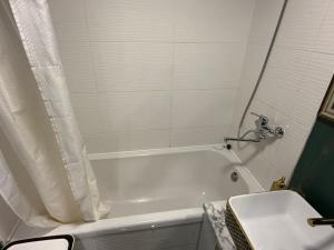 a bathroom with a white tub and a sink at Welcome to Dovas Home in Anykščiai +8 photos