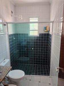 une salle de bain avec toilettes et douche en verre dans l'établissement Casa 10 pessoas - praia das Astúrias, Guarujá, à Guarujá