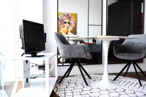 a room with a table and two chairs and a television at Charming studio by Lake Lucerne in Buochs