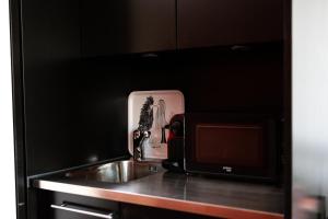 a kitchen with a sink and a microwave at Charming studio by Lake Lucerne in Buochs