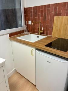 uma cozinha com um lavatório branco e um balcão em Studio Cozy avec terrasse idéalement situé em Angers