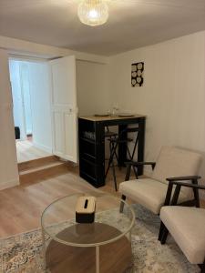 uma sala de estar com uma mesa de centro e uma secretária em Studio Cozy avec terrasse idéalement situé em Angers