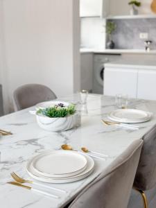 - une table à manger avec des assiettes blanches et de l'argenterie dans l'établissement Modern 3-Bed House Near Attractions & Beach, à Blackpool