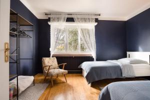 ein Schlafzimmer mit blauen Wänden und einem Bett und einem Stuhl in der Unterkunft La Rose in Schiltigheim