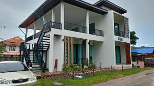 ein weißes Haus mit einem davor geparkten Auto in der Unterkunft Ck Home Lanta in Phra Ae beach + 36 Fotos