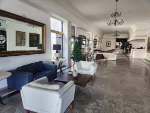 - un salon avec un canapé bleu et des fauteuils blancs dans l'établissement Aconchego de Apartamento Conforto de hotel, localização TOP, à Salvador