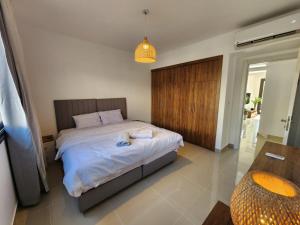 ein Schlafzimmer mit einem Bett, auf dem zwei Handtücher liegen in der Unterkunft El Gouna Poolfront Cozy Stay 2BR in Hurghada