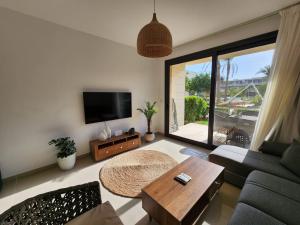 ein Wohnzimmer mit Sofa und Tisch in der Unterkunft El Gouna Poolfront Cozy Stay 2BR in Hurghada