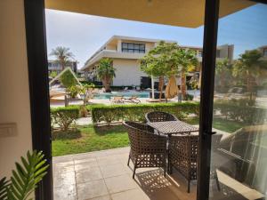 eine Terrasse mit Tisch und Stühlen und Blick auf ein Haus in der Unterkunft El Gouna Poolfront Cozy Stay 2BR in Hurghada