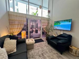 ein Wohnzimmer mit zwei Sofas und einem Flachbildfernseher in der Unterkunft Bucerias Beauty by sport park east side walk to beach in Bucerías