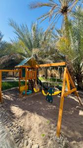 a playground on the beach with a palm tree at Casa Blanca - calm space for soul revival in Ādam