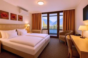 a hotel room with a bed and a large window at AMBER HOTEL Bavaria in Bad Reichenhall