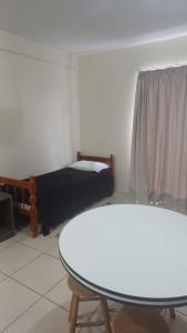 a room with a bed and a table and a table and a couch at Praticita Apart Hotel Ltda in São Gabriel