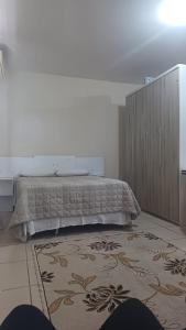 a bedroom with a bed and a large rug at Praticita Apart Hotel Ltda in São Gabriel