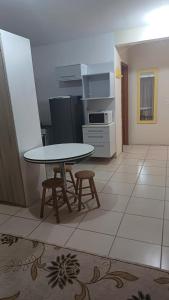 a kitchen with a table and stools in a room at Praticita Apart Hotel Ltda in São Gabriel