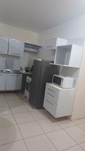 an empty kitchen with white cabinets and appliances at Praticita Apart Hotel Ltda in São Gabriel +3 photos
