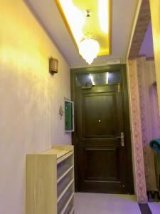 Un pasillo con una puerta negra y una mesa. en Grand apartments, en Lahore 3 fotos más