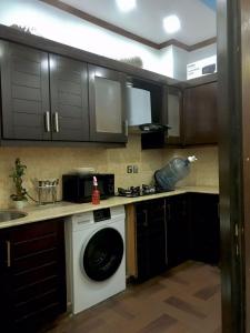 una cocina con lavadora y fregadero en Grand apartments, en Lahore