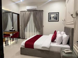 ein Schlafzimmer mit einem Bett und einem Schreibtisch darin in der Unterkunft Holiday One Hotel & Suites in Karatschi