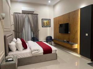 ein Hotelzimmer mit einem Bett und einem Fernseher in der Unterkunft Holiday One Hotel & Suites in Karatschi + 31 Fotos