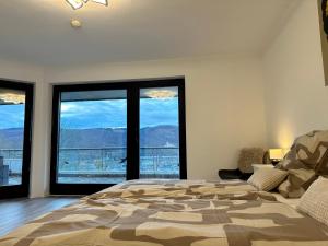 ein Schlafzimmer mit einem großen Bett und einem großen Fenster in der Unterkunft Wunderschöne Familienvilla mit Schlossblick in Lahnstein