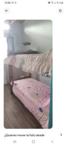 ein kleines Bett mit einem rosa Laken darauf in der Unterkunft Cabañitas surf bruskas in Miramar