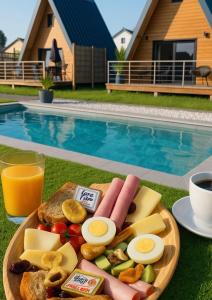 Un plato de comida con huevos y pan junto a una piscina en Lodge Lady Tipi 2, 