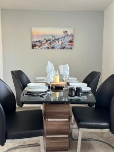 a dining room with a black table and chairs at Spacious two bedroom flat, entire property in Greenock +12 photos