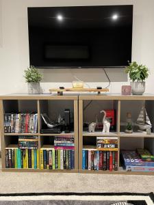 a television on top of a book shelf with books at Spacious two bedroom flat, entire property in Greenock