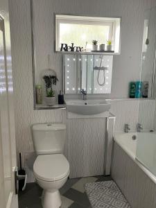 a bathroom with a toilet and a sink and a window at Spacious two bedroom flat, entire property in Greenock +12 photos