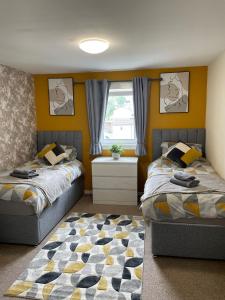 a bedroom with two beds and a window at Spacious two bedroom flat, entire property in Greenock