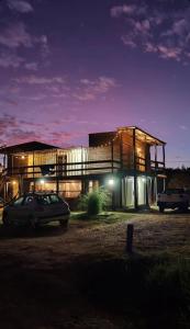 a building with a car parked in front of it at Serendipia Hostel Punta Rubia in La Pedrera